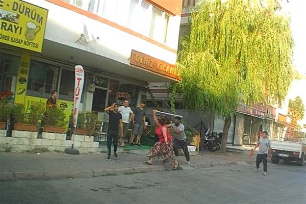 Eli sopalı kadın önüne gelen erkeği dövdü